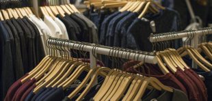 Wear hanging on rack in clothing store. Sale and shopping concept