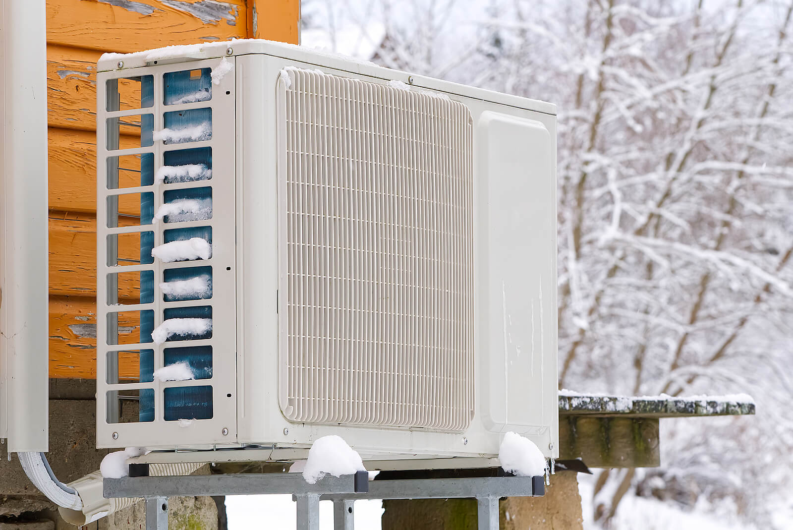 Heat Pump Near A Wooden House In Winter.