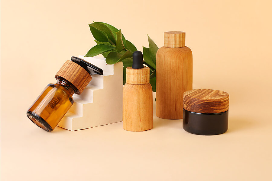 Eco-friendly tubes and bottles from the natural wood and brown glass near the geometrical pedestal.