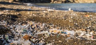 Small plastic parts and microplastics on the sand beach. Global ocean pollution. Microplastic in water and food. Global ocean pollution.